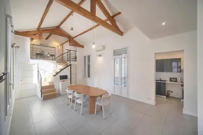 a kitchen and dining room with a wooden table and chairs at MIPIM Walk-to-Palais 100sqm Loft 2 Ensuite Suites 3 Bathrooms Terrace Business Ready in Cannes