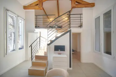 a home with a staircase and a tv in a room at MIPIM Walk-to-Palais 100sqm Loft 2 Ensuite Suites 3 Bathrooms Terrace Business Ready in Cannes
