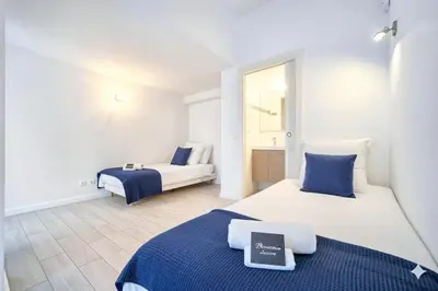 two beds in a room with white and blue at MIPIM Walk-to-Palais 100sqm Loft 2 Ensuite Suites 3 Bathrooms Terrace Business Ready in Cannes