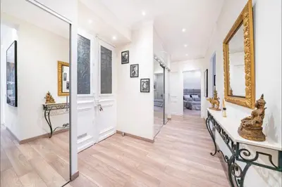 a large room with a hallway with a mirror at 120 m2 GRAND STANDING CENTRE PROCHE PALAIS FESTIVALS in Cannes