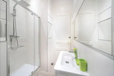 a white bathroom with a sink and a shower at 120 m2 GRAND STANDING CENTRE PROCHE PALAIS FESTIVALS in Cannes