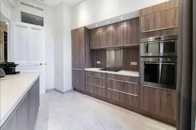 a large kitchen with wooden cabinets and a stove at 120 m2 GRAND STANDING CENTRE PROCHE PALAIS FESTIVALS in Cannes