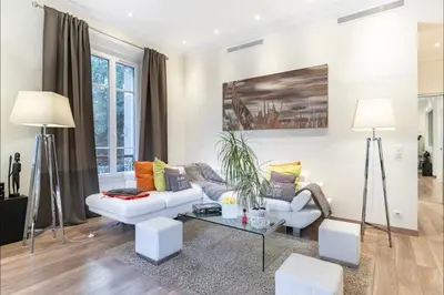 a living room with a couch and a table at 120 m2 GRAND STANDING CENTRE PROCHE PALAIS FESTIVALS in Cannes