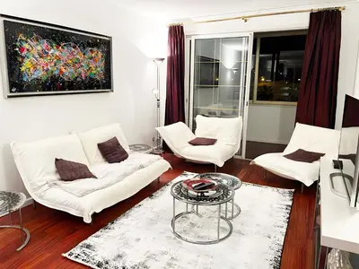 a living room with two white chairs and a table at Villa St Marc - Standing Presta in Cannes