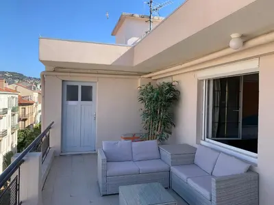 a balcony with two white chairs and a window at Villa St Marc - Standing Presta in Cannes