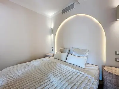 a bedroom with a large white bed with an archway at 38 m2 - Suite de luxe, terrasse vue mer, Croisette in Cannes