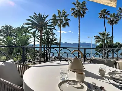 a table with a tea kettle on a balcony with palm trees at 38 m2 - Suite de luxe, terrasse vue mer, Croisette in Cannes
