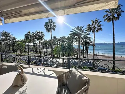 a balcony with a table and chairs and a view of the beach at 38 m2 - Suite de luxe, terrasse vue mer, Croisette in Cannes