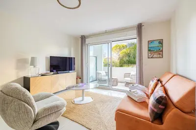 a living room with a couch and a tv at Spacious Apartment a c 1BR 4P – With Pool in Cannes