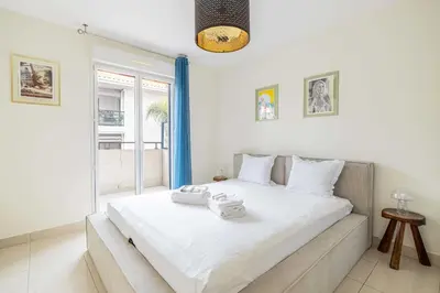 a bedroom with a bed with two towels on it at Spacious Apartment a c 1BR 4P – With Pool in Cannes