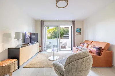 a living room with a couch and a television at Spacious Apartment a c 1BR 4P – With Pool in Cannes