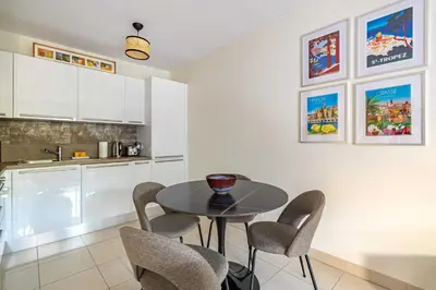 a kitchen and dining room with a table and chairs at Spacious Apartment a c 1BR 4P – With Pool in Cannes