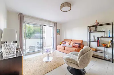 a living room with a couch and a chair at Spacious Apartment a c 1BR 4P – With Pool in Cannes