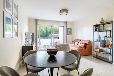 a living room with a table and chairs at Spacious Apartment a c 1BR 4P – With Pool in Cannes