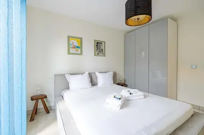 a bedroom with a white bed with two towels on it at Spacious Apartment a c 1BR 4P – With Pool in Cannes