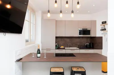 a kitchen with a counter with a bottle of wine at Romy YourHostHelper in Cannes