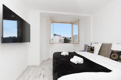 a white bedroom with a large bed with two towels at Romy YourHostHelper in Cannes