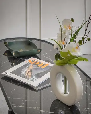 a glass table with a vase with flowers and a magazine at La Terrasse in Cannes