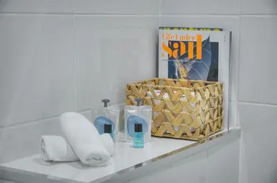 a shelf in a bathroom with toilet paper and a magazine at La Terrasse in Cannes