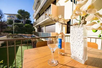 a wooden table with a bottle and a wine glass at Chic Cinema Apartment in Cannes in Cannes