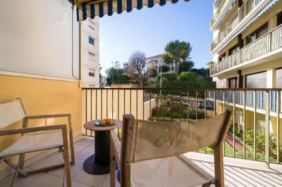 a balcony with a table and a chair on a balcony at Chic Cinema Apartment in Cannes in Cannes