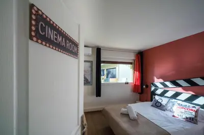 a bedroom with a bed with a red wall at Chic Cinema Apartment in Cannes in Cannes