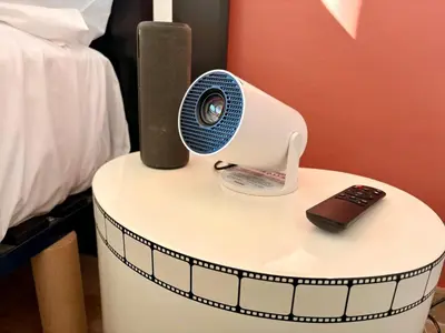 a small white table with a fan and a remote control at Chic Cinema Apartment in Cannes in Cannes