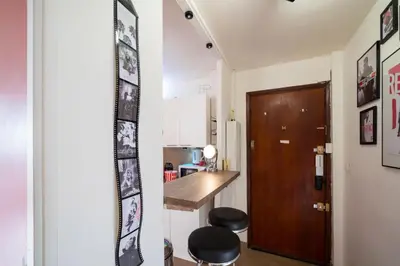 a small kitchen with a table and stools in a room at Chic Cinema Apartment in Cannes in Cannes