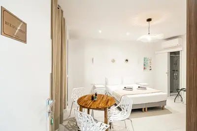 a white dining room with a table and chairs at 27 VAURTIN - Modern and renovated studio Cannes city centre in Cannes