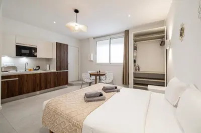 a bedroom with a large bed and a kitchen at 27 VAURTIN - Modern and renovated studio Cannes city centre in Cannes