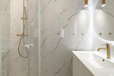 a white bathroom with a shower and a sink at 27 VAURTIN - Modern and renovated studio Cannes city centre in Cannes
