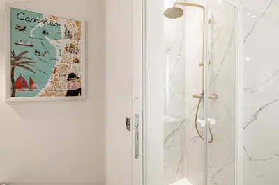 a bathroom with a shower and a picture on the wall at 27 VAURTIN - Modern and renovated studio Cannes city centre in Cannes
