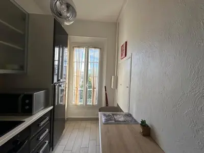 a kitchen with a table and a microwave and a window at Studio w parking, close to film Festival Palace in Cannes