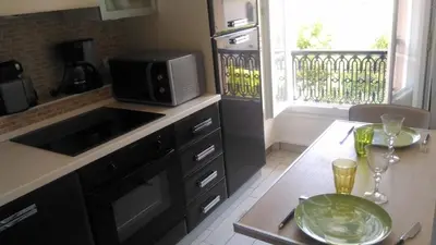 a kitchen with a microwave and a table with a plate at Studio w parking, close to film Festival Palace in Cannes