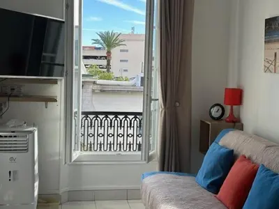 a living room with a view of a balcony at Studio w parking, close to film Festival Palace in Cannes