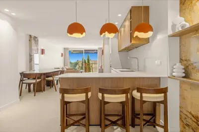 a kitchen with a bar with wooden stools at 121 MARECHAL - 3-Bedroom Apartment Sea View and Parking in Cannes