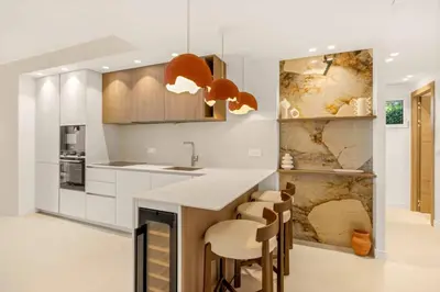 a kitchen with a counter and some chairs in it at 121 MARECHAL - 3-Bedroom Apartment Sea View and Parking in Cannes