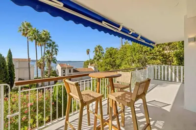 a balcony with a table and chairs and a view of the ocean at 121 MARECHAL - 3-Bedroom Apartment Sea View and Parking in Cannes
