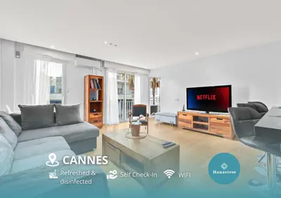 a living room with a couch and a tv at Luxueux deux pièces - Proche de la mer - FU in Cannes
