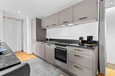 a kitchen with white cabinets and a stove top oven at Luxueux deux pièces - Proche de la mer - FU in Cannes