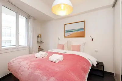a bedroom with a large bed with two towels on it at Le Grain d'Or YourHostHelper in Cannes
