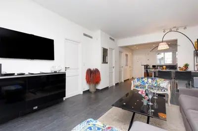 a living room with a large flat screen tv on the wall at Le Grain d'Or YourHostHelper in Cannes