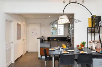 a kitchen with a table with chairs and a dining room at Le Grain d'Or YourHostHelper in Cannes