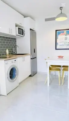 a kitchen with a washing machine and a table at Appartement bord de mer in Cannes