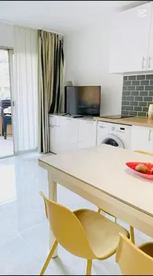 a kitchen with a table and chairs and a television at Appartement bord de mer in Cannes