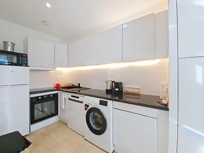 a kitchen with white cabinets and a washing machine at Cannes 2 bedrooms & 2 bathrooms Apartment - 43A in Cannes