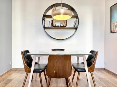 a dining room with a round mirror and a table and chairs at Cannes 1 bedroom apartment - 9BC in Cannes