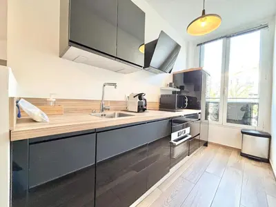 a kitchen with black cabinets and a sink at Cannes 1 bedroom apartment - 9BC in Cannes