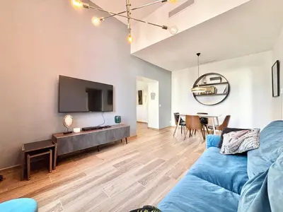 a living room with a blue couch and a tv at Cannes 1 bedroom apartment - 9BC in Cannes