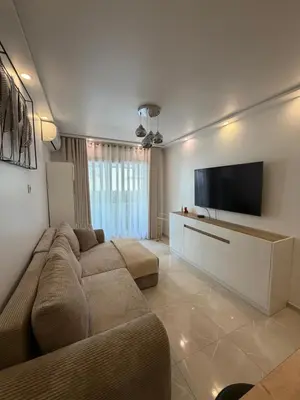 a living room with a couch and a flat screen tv at Cannes Center Appartement F9 in Cannes